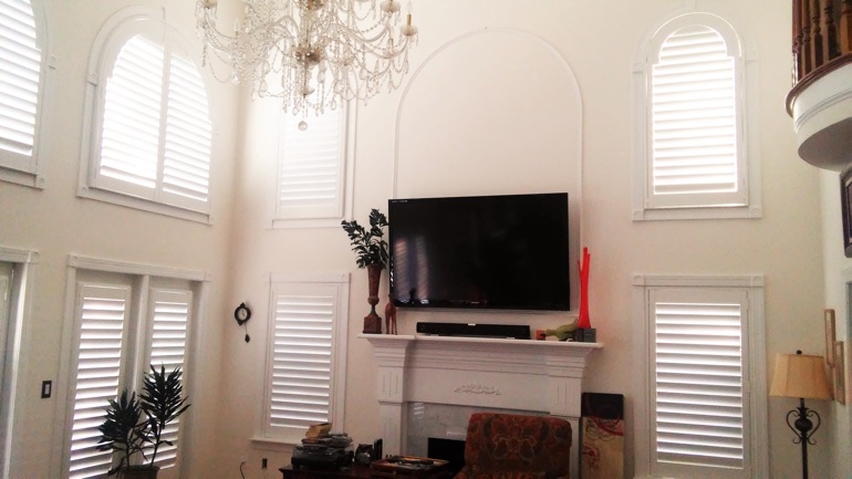 Sacramento great room with mounted TV and high-ceiling windows.